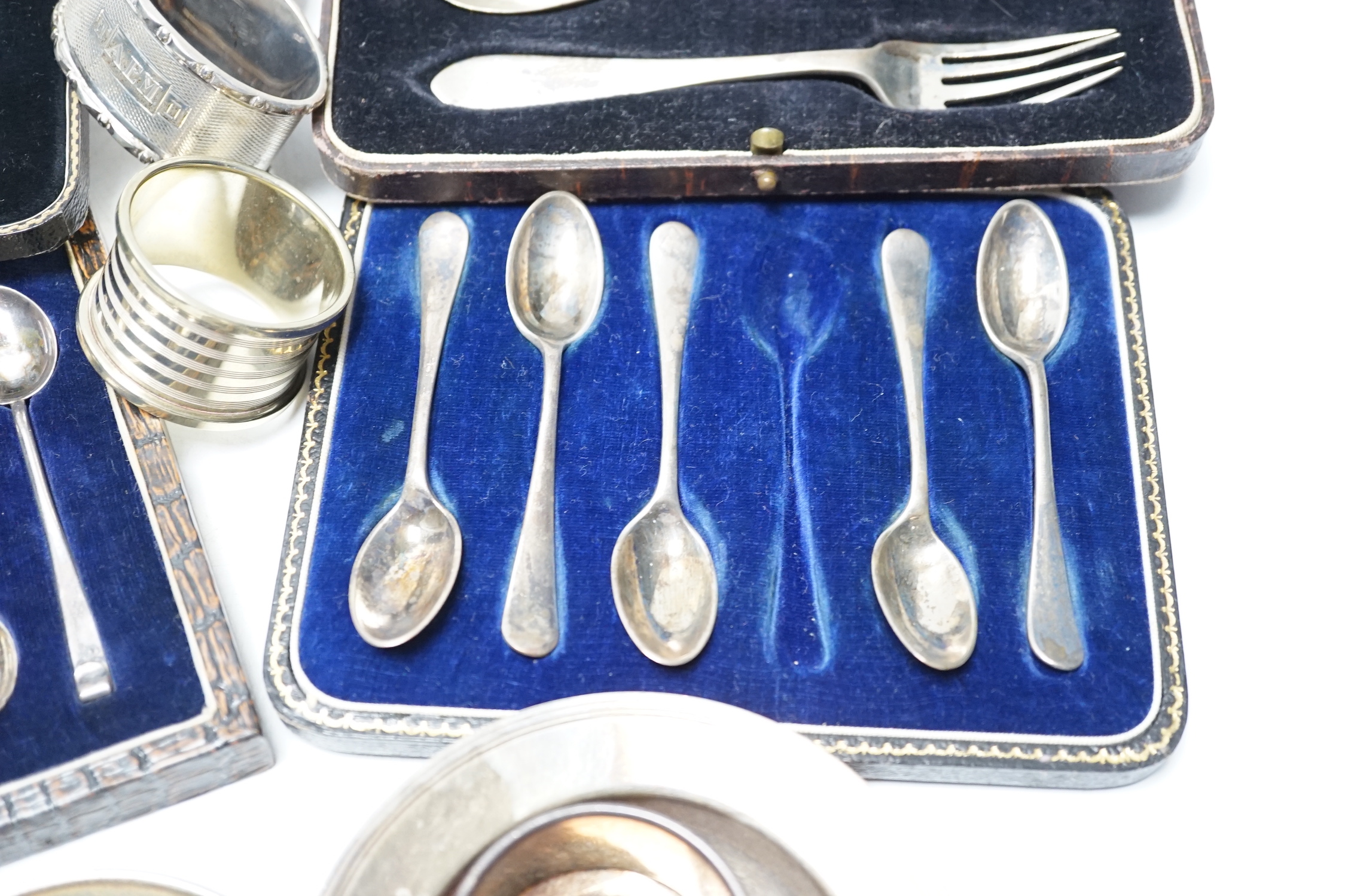 Four various silver serviette rings and a plated napkin ring, two small silver dishes, three various boxed sets of silver flatware and one part set of silver flatware.
